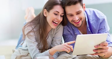 Happy couple checking something on a tablet